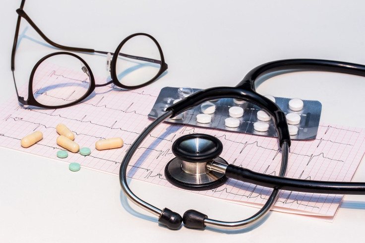 A picture of an electrocardiogram result ("ECG") result with a stethoscope and reading glasses.