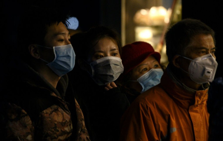 People wearing protective facemasks queue for food in Shanghai