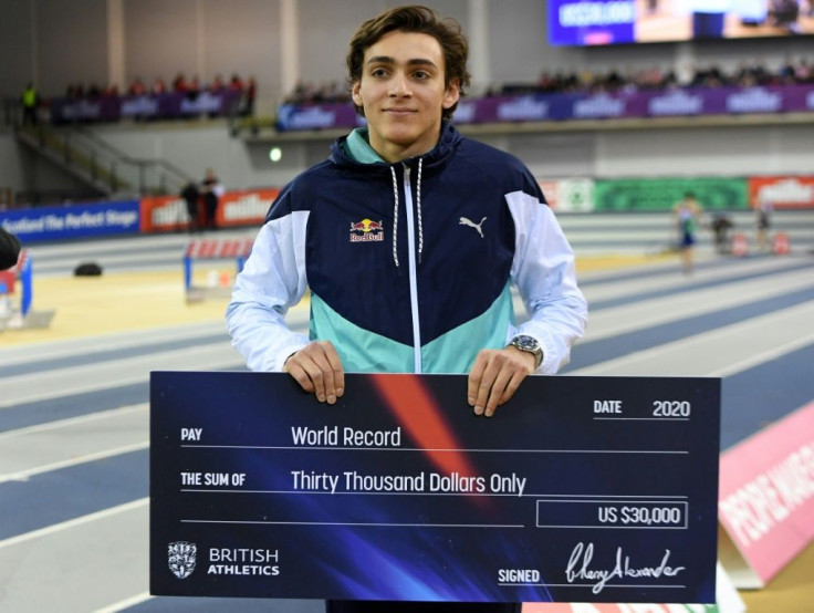 Sweden's Armand Duplantis poses with his cheque after breaking the world pole vault record in Glasgow