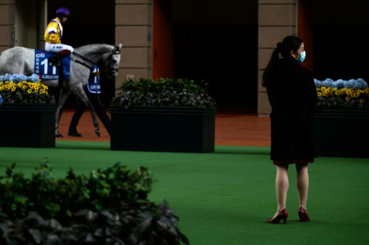 A Hong Kong Jockey Club employee wears a face mask in the parade ring at an empty Sha Tin racecourse on Hong Kong Gold Cup day