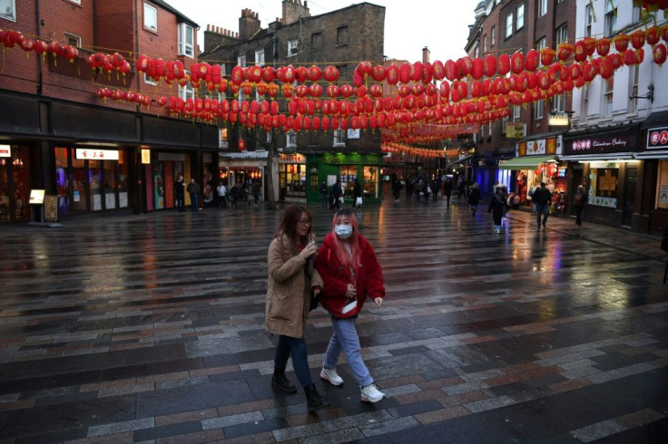 A visitor wears a face mask as she walks through London's Chinatown district