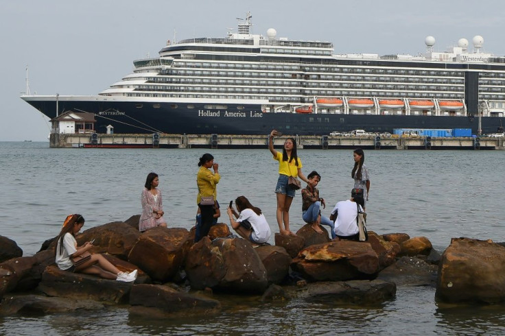 Cambodians pose for selfies with the Westerdam in the background in Sihanoukville