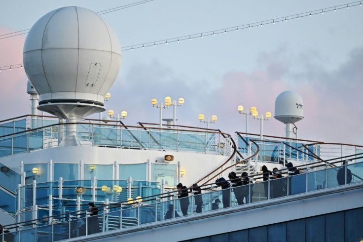 People still in quarantine stand on the deck of the Diamond Princess in Yokohama on February 18, 2020