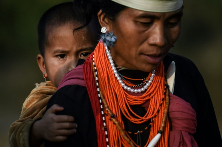 A Naga tribeswoman carrying a child at the end of an overnight ceremony to bless the harvest in Satpalaw Shaung village in Myanmar's Sagaing region