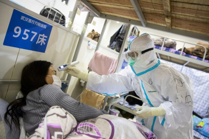 A health worker checks the temperature of a patient at a hospital in Wuhan