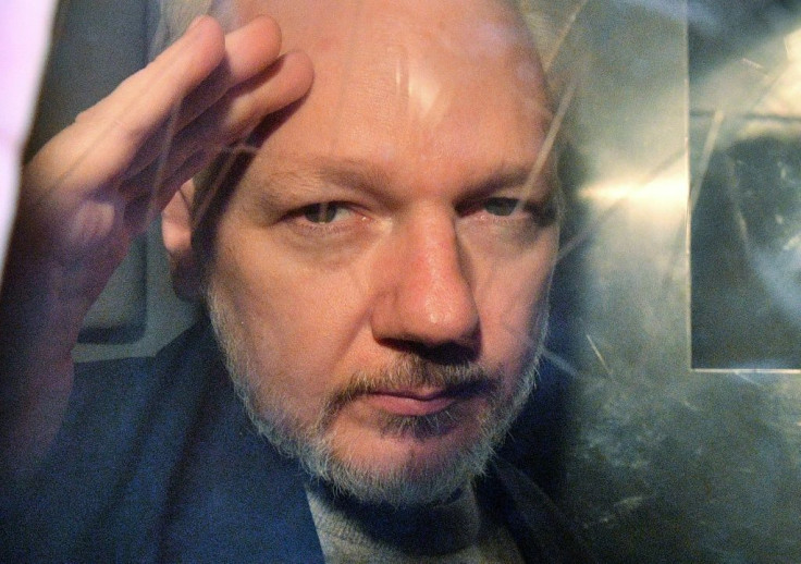 Julian Assange gestures from the window of a prison van in May 2019 after a court in London sentenced him to 50 weeks in prison for breaching his bail conditions in 2012