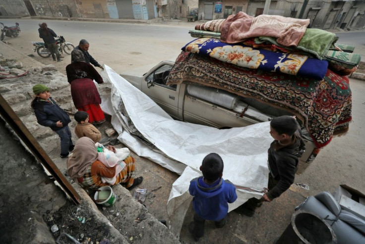 Abu Mohammed and his children scramble to cram what belongings they can onto the back of a pick-up