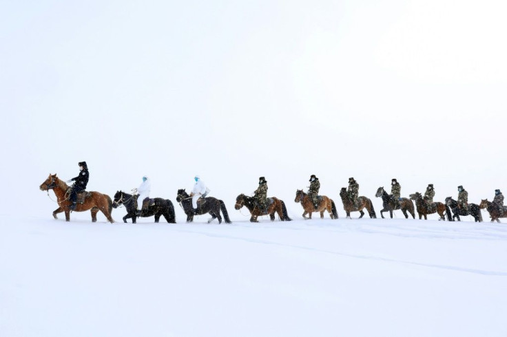 Police officers wearing protective face masks ride horses through the snow to visit residents of remote Altay in  China's Xinjiang region, and promote the awareness of the Coronavirus