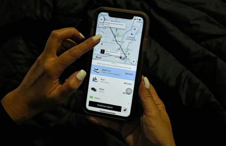 A woman checks the Uber transport application on her mobile phone after authorities ordered its suspension in Colombia, in Bogota on December 20, 2019
