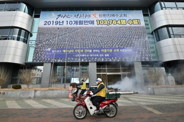 Workers spray disinfectant outside the Shincheonji church in the South Korean city of Daegu after members fell ill with the novel coronavirus
