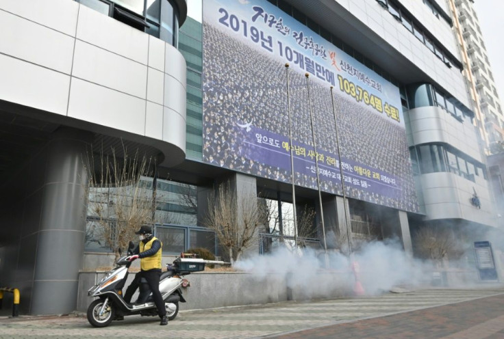 A South Korean health official sprays disinfectant in front of the Daegu branch of the Shincheonji Church of Jesus Daegu