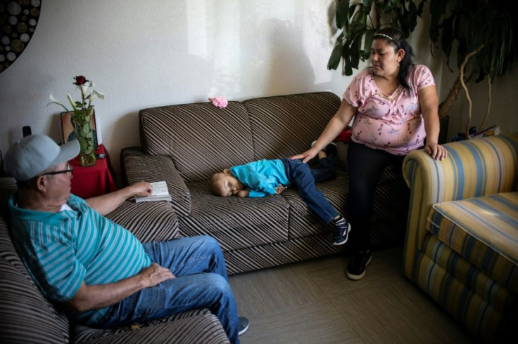 Mexican toddler Cristal Flores, diagnosed with cancer, rests on a couch between her parents at a relative's house in Cuautitlan, Mexico