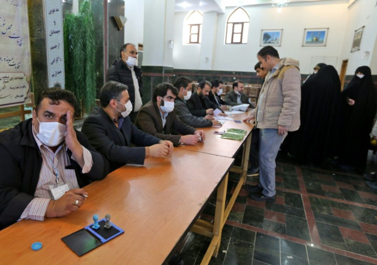 Organisers wear masks as they oversee voting in Iran's Friday parliamentary election days after the coronavirus outbreak first emerged