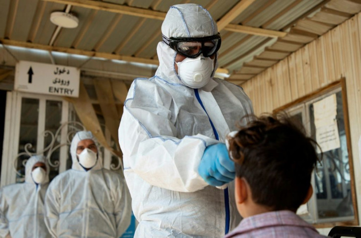 Medics carry out health checks on an Iraqi returning from Iran through the Shalamjah border crossing near Basra