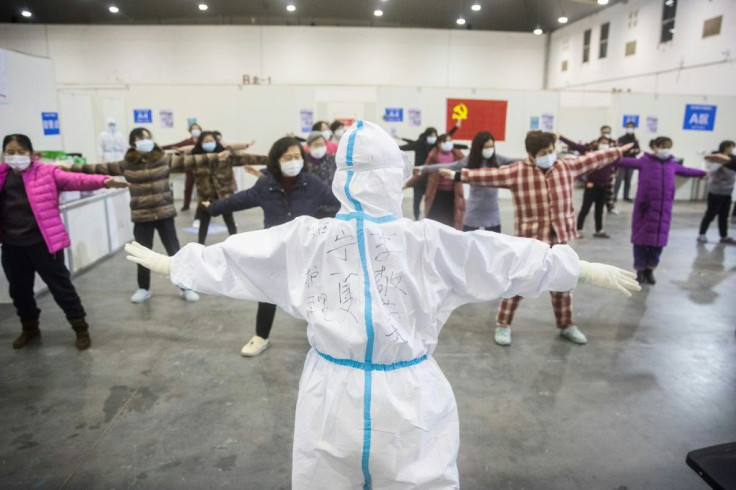 A medical staffer leads patients who have displayed mild symptoms of the COVID-19 illness in group exercises at a hospital in Wuhan, the epicenter of the global outbreak