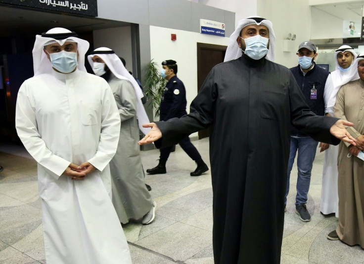 Kuwaiti health minister Sheikh Basel al-Sabah (R) speaks to the press at Sheikh Saad Airport on Sunday, as Kuwaitis returning from Iran wait before being taken to hospital to be tested for coronavirus