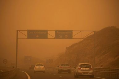 Cars drive on the TF-1 highway during a sandstorm in Santa Cruz de Tenerife, Spain, on February 23, 2020; airports on Spain's Canary Islands were closed after strong winds carrying red sand from the Sahara shrouded the tourist hotspot