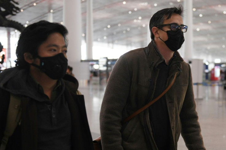 Wall Street Journal reporters Philip Wen (left) and Josh Chin walk through Beijing Capital Airport on their way out of China
