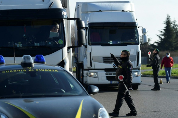 Italian police at the entrance to the small town of Casalpusterlengo, southeast of Milan, as authorities try to halt the spread of the coronavirus which claimed a fourth victim in Italy on Monday