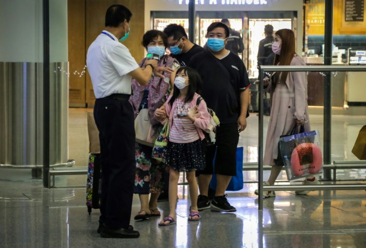 Passengers have their temperature checked on arrival at Hong Kong International Airport