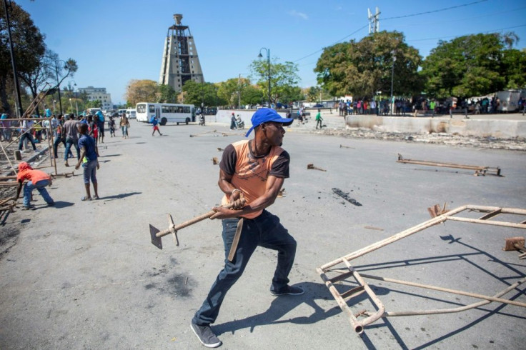 People clean the Champ de Mars, in Port-au-Prince, Haiti, on February 18, 2020, a day after police officers reportedly set fire to carnival stands: the area was completely deserted Monday after police attacked the nearby army headquarters