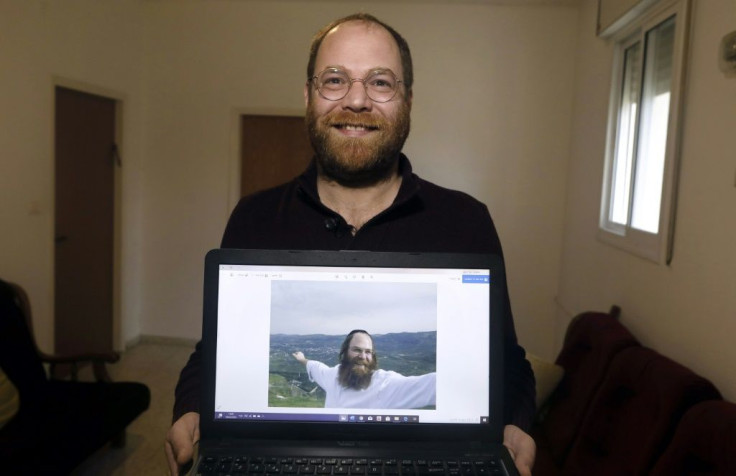 Avi Tfilinksi shows an old picture of himself as an observant ultra-Orthodox Jew at his apartment on the outskirts of Jerusalem