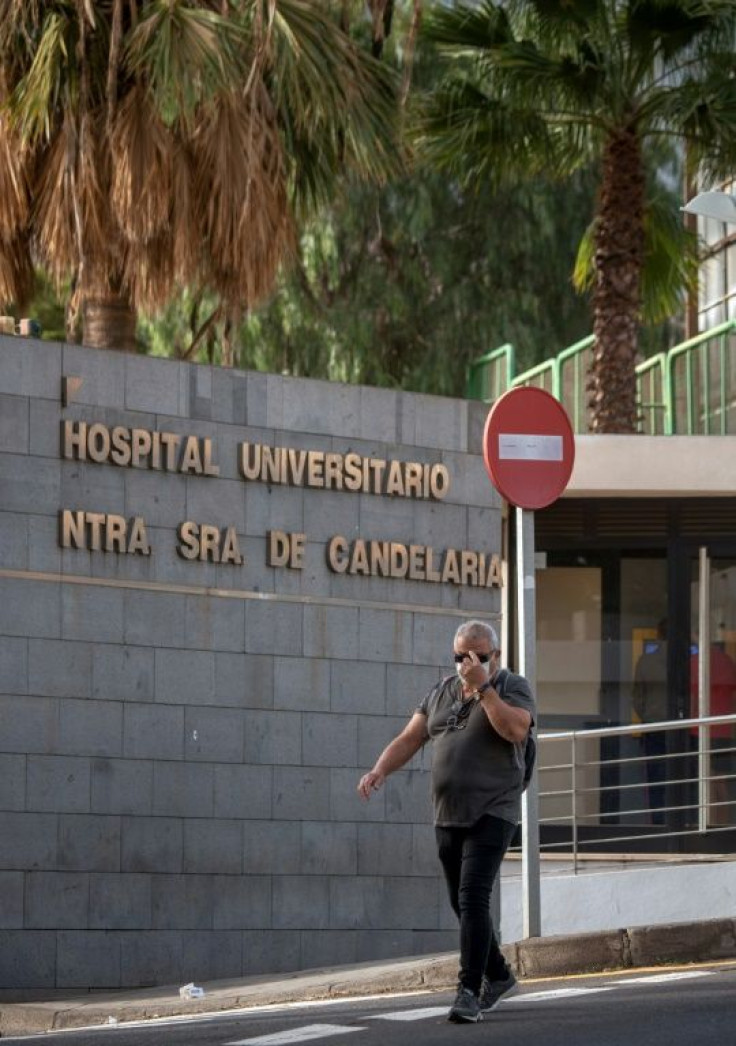 A man wearing a mask walks past Nuestra Senora de Candelaria University Hospital in Santa Cruz de Tenerife, where an Italian national has been isolated after testing positive for the novel coronavirus.