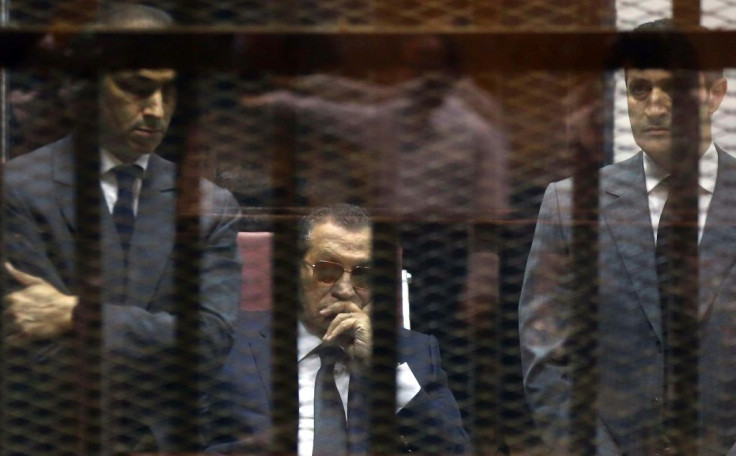 Hosni Mubarak sits in the defendantâs cage between his sons during a hearing in one of his trials following his ouster in 2011