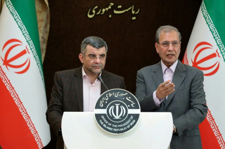 Iran's deputy health minister (L), who has tested positive for the novel coronavirus, coughed and wiped sweat from his brow during a press conference in Tehran on Monday with government spokesman Ali Rabiei