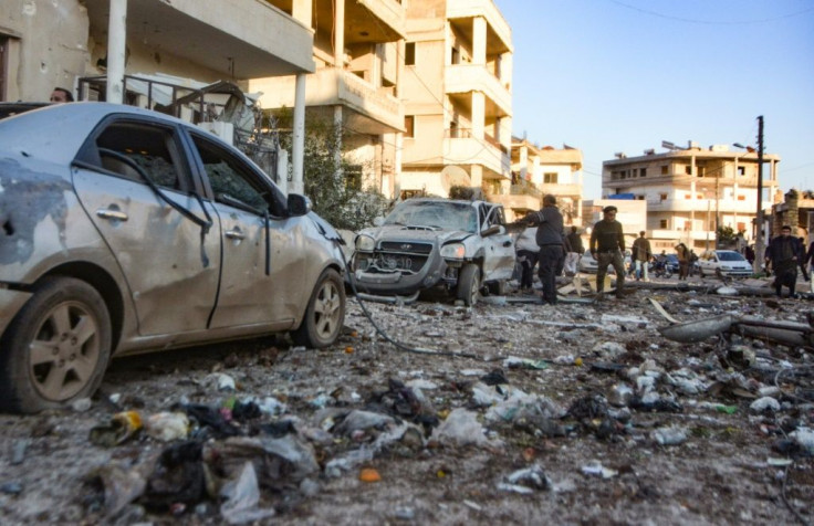 Damaged cars line a street following an air strike in Maarat Misrin on Tuesday