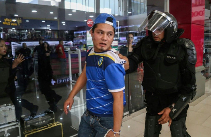 An opposition demonstrator is arrested by a police officer during a protest at the Metrocentro mall in Managua