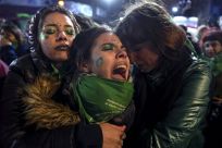 Activists in favor of abortion rights comfort each other outside the National Congress in Buenos Aires after senators rejected the bill to legalize the abortion in 2018
