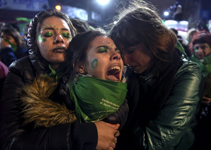 Activists in favor of abortion rights comfort each other outside the National Congress in Buenos Aires after senators rejected the bill to legalize the abortion in 2018