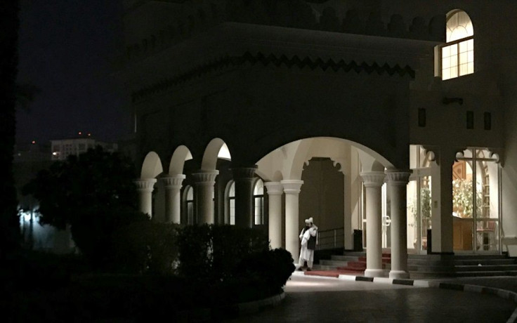 A member of the Taliban negotiating team speaks on his phone outside the venue housing talks with US negotiators in the Qatari capital Doha last August