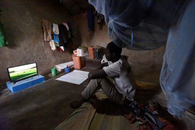 Footy night: Ousmane Kantcho settles down to watch an English Premier League match, thanks to solar energy
