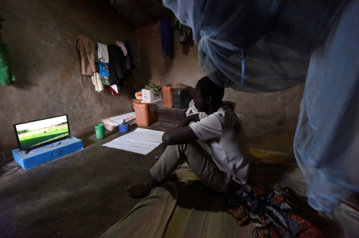 Footy night: Ousmane Kantcho settles down to watch an English Premier League match, thanks to solar energy