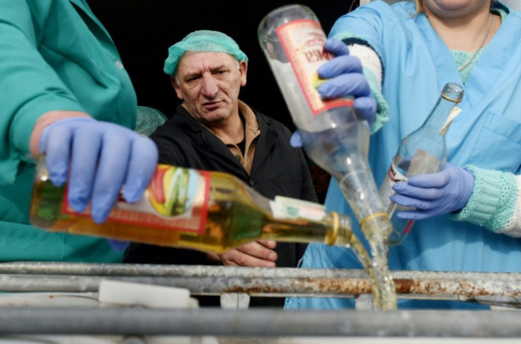 A supervisor looks on as workers empty bottles of the adulterated vodka in the town of Vynnyky, western Ukraine