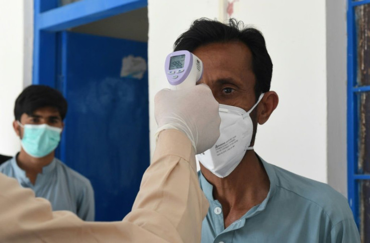 A doctor checks the temperature of a man on February 25 as he returns from Iran to Pakistan, where two cases of novel coronavirus have been confirmed