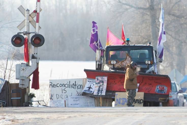 A First Nations protester walk in front of a snow plow blade that has signatures from the  WetÊ¼suwetÊ¼en hereditary chiefs as part of a train blockade in Tyendinaga, near Belleville, Ontario, Canada on February 21, 2020