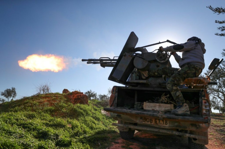 A fighter fires a truck-mounted gun towards Syrian government positions in Saraqeb as the rebels prepare to move on the key northwestern crossroads town