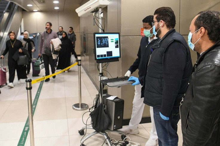 Temperature scanners are used to screen passengers arriving at Kuwait international airport for fever