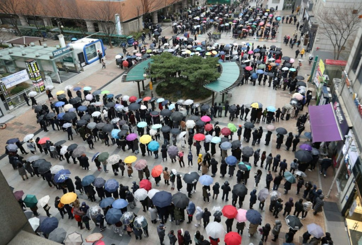 People wait in line to buy face masks from a department store in Seoul