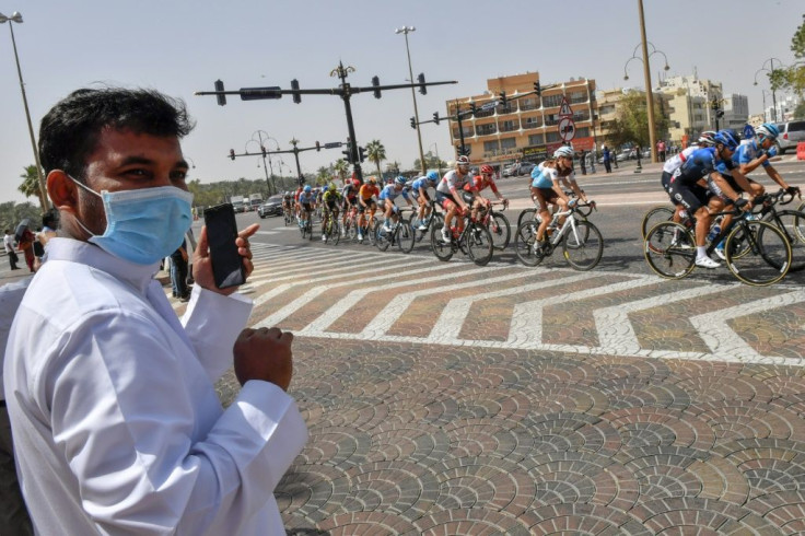 A man wearing a surgical mask looks on as the peleton rode by on Thursday's stage five