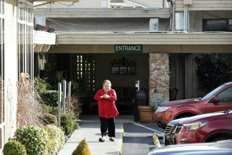 A woman disinfects her hands as she leaves the Life Care Center of Kirkland, Washington, where one staffer and one resident were diagnosed with the novel coronavirus