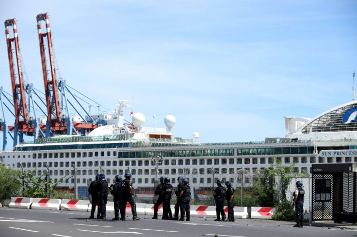 French police officers face demonstrators in Le Port on March 1, 2020, as people protest passengers from the Sun Princess cruise ship on the Indian Ocean island of La Reunion disembarking without having temperatures checked; The incident came hours after
