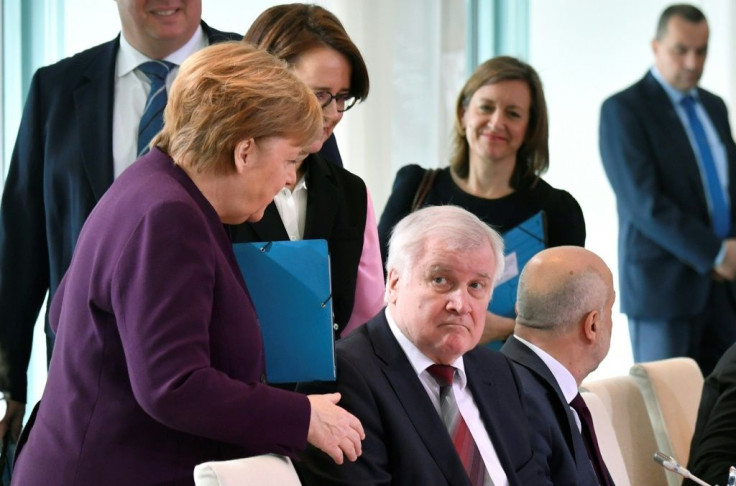Merkel reached out to greet Horst Seehofer at a meeting on migration in Berlin