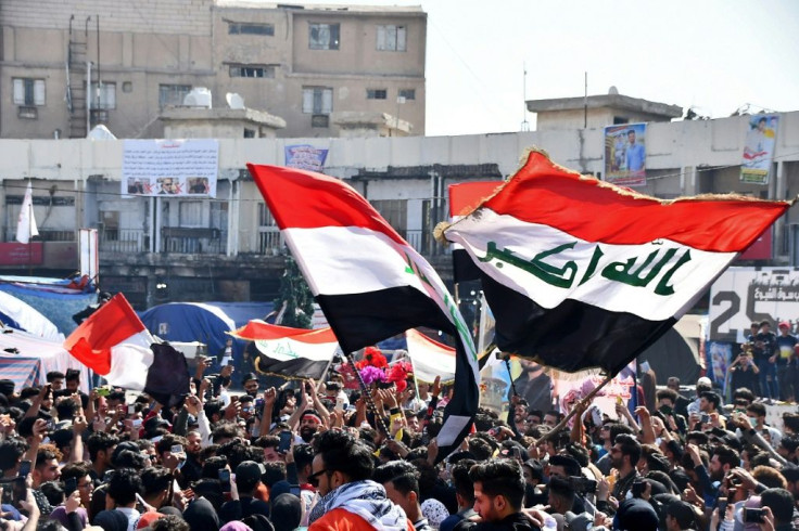 Student protesters march with Iraqi national flags during an anti-government demonstration in Iraq's southern city of Nasiriyah
