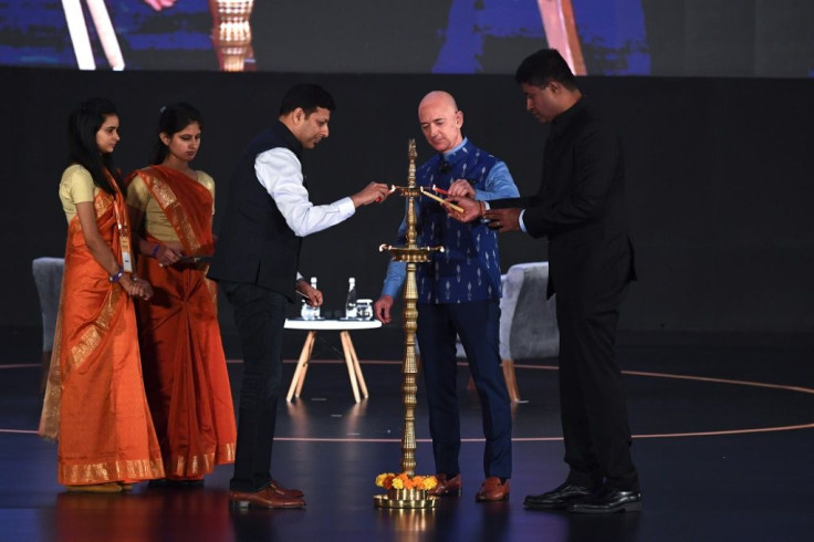 Amazon CEO Jeff Bezos (R) lights a traditional lamp along with Amit Agarwal (3L), senior vice president and country manager for Amazon India, at Amazon's Smbhav event in New Delhi