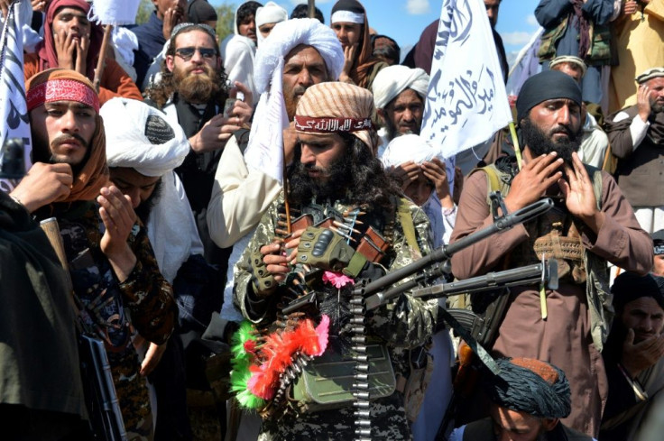 Afghan Taliban fighters and villagers attend a gathering in Alingar district of Laghman Province on the day the militants said they were resuming operations against Afghan government targets