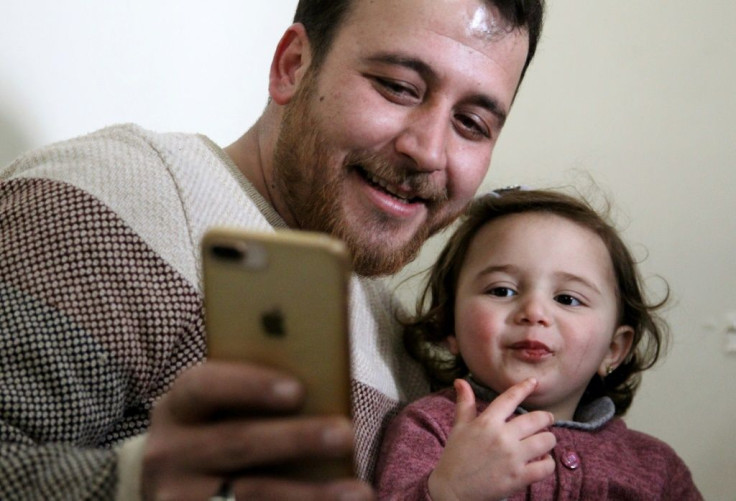 Syrian father Abdullah al-Mohammed with his three-year-old daughter Salwa. A video in which she laughs every time an explosion goes off was widely shared on social media as a heartening but grim reminder of Idlib residents' daily lives